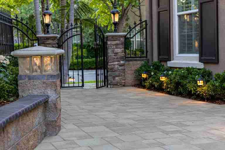 Elegant home entrance with stone pathway and wrought iron gate for curb appeal and security.
