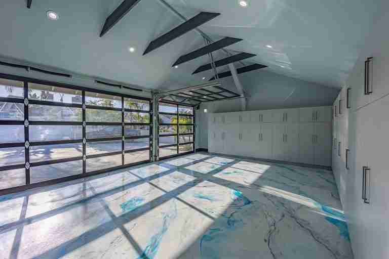 Garage with large glass doors and organized storage cabinets. Huntington Beach CA