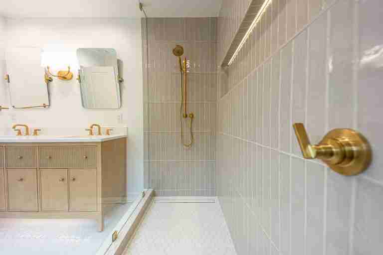 Modern bathroom with beige tiles and gold fixtures for a stylish upgrade in Fullerton CA