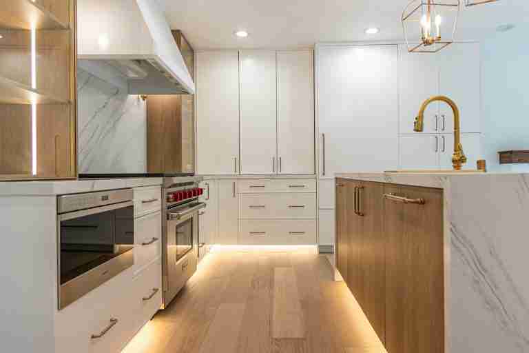 Modern white and wood kitchen with sleek cabinetry and stainless steel appliances.