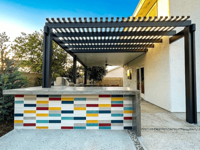 Outdoor patio with colorful tiled bar and black pergola in a residential backyard in Fullerton CA