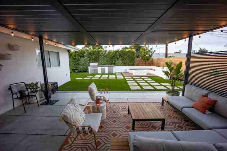 Outdoor covered patio with seating area and green lawn in Fountain Valley, CA.