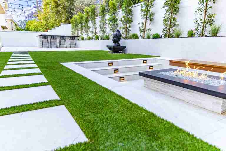 Backyard with fire pit, modern landscaping, and green grass. Buena Park, CA