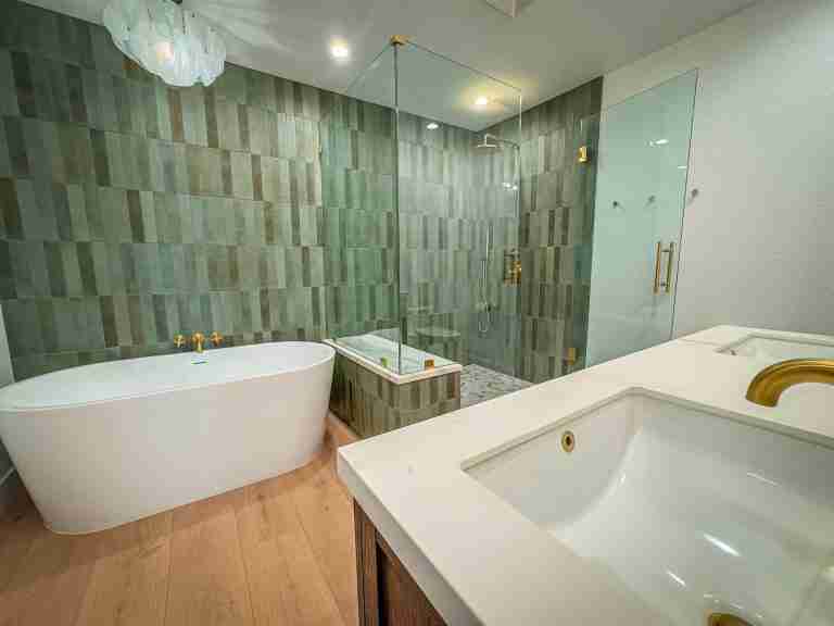 bathroom remodeling in orange ca Elegant bathroom featuring green tile walls, a freestanding bathtub, and a glass-enclosed shower in Orange CA