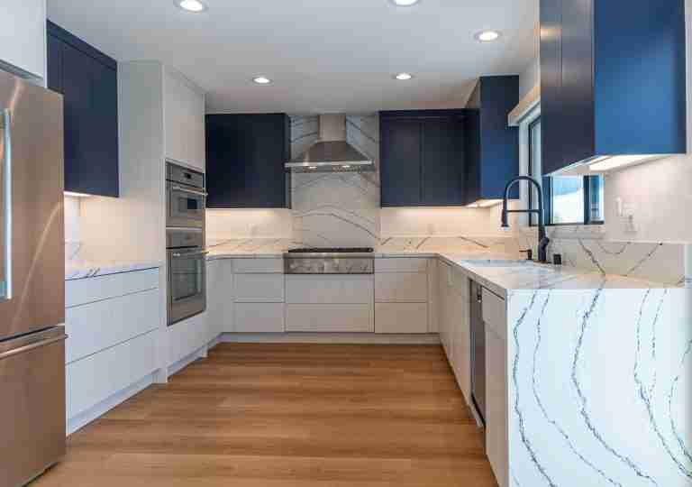 Modern kitchen with blue and white cabinets, marble countertops, stainless steel appliances, Buena Park, CA