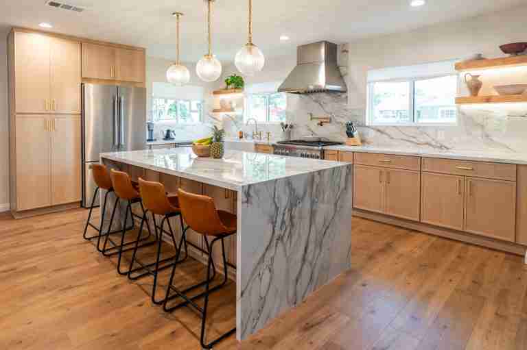 Modern kitchen with marble island, wooden cabinets, and stainless steel appliances. Laguna Niguel CA