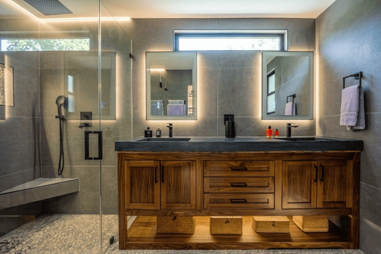 Modern bathroom vanity with double mirrors, black fixtures, and wooden cabinetry. Laguna Niguel CA