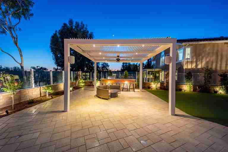 Outdoor patio cover in Coto de Caza, CA with seating area and lighting.