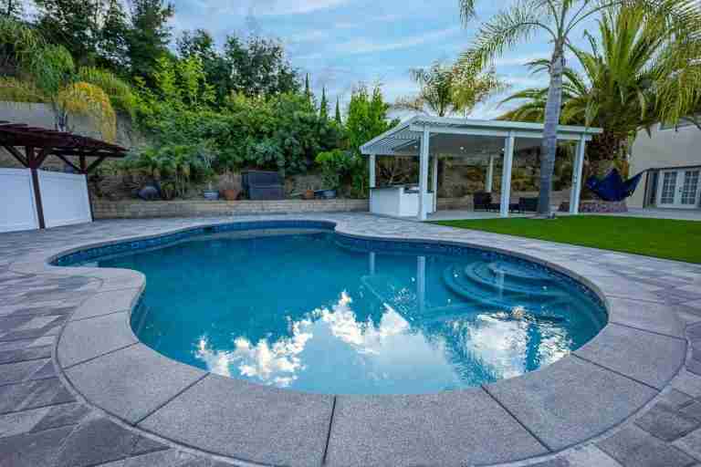 Beautiful backyard pool in Coto de Caza CA with palm trees and lounge area.