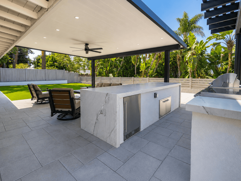 Outdoor kitchen in Tustin CA with marble countertops and seating area.