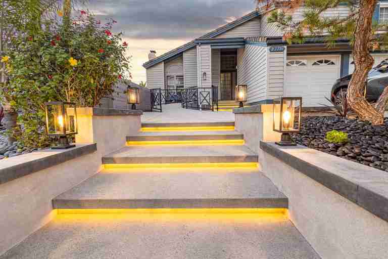 Tustin CA modern home with illuminated concrete steps and landscaping.